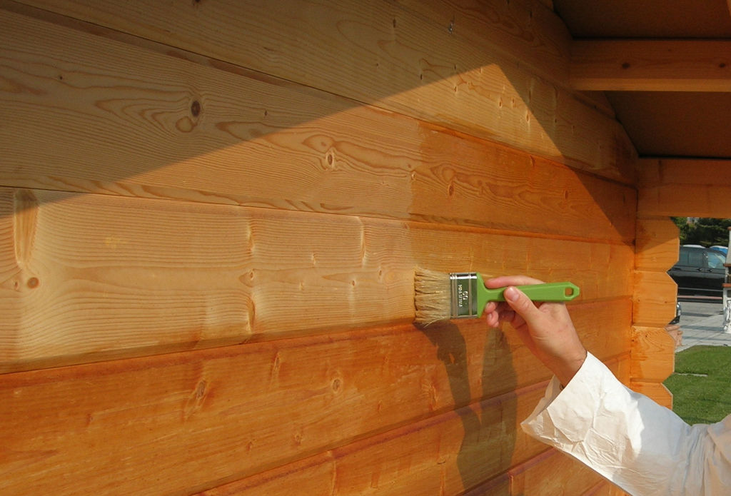 Applicazione a pennello di Everwood in una casetta da giardino in legno.